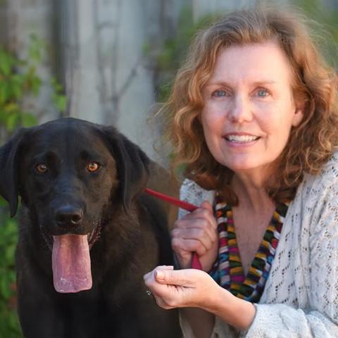 Abby Jones outside next to black dog