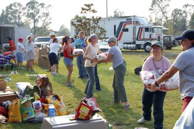 Line of people moving large bags of pet food during the Hurricane Katrina rescue efforts