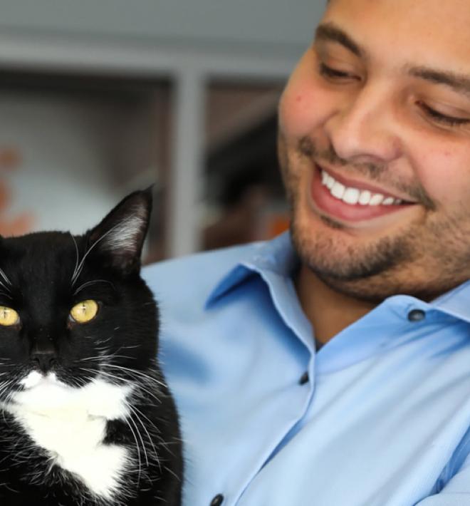 Smiling person holding a cat