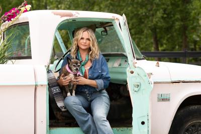 Miranda Lambert with Delta Dawn her dog sitting in a pickup truck