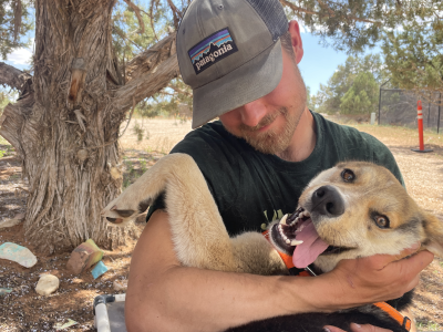 Will holding Durango the dog beside a tree